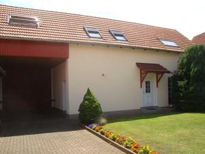 a white house with a red roof and a garage at Ferienwohnung Zschornack in Wittichenau