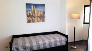 1 dormitorio con 1 cama y una pintura en la pared en Céntrico, Confortable y Cómodo en Córdoba