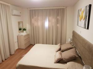 a bedroom with a large bed and a window at Marianna Hotel Apartments in Limassol