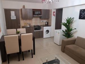a kitchen and living room with a table and a couch at Marianna Hotel Apartments in Limassol
