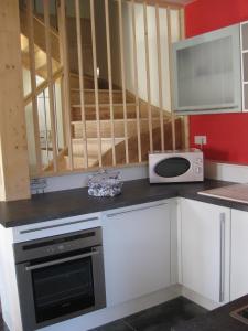 a kitchen with a stove and a microwave at La petite maison in Tauves