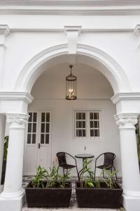 an archway with chairs and a table in a building at The Southern Boutique Hotel in George Town +29 photos