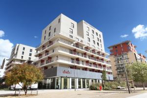 Un alto edificio bianco in una strada di città di Odalys City Lyon Confluence a Lione