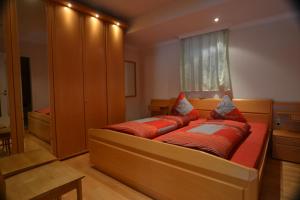 a bedroom with a large bed with red pillows at Schwarwald Apartment in Schluchsee
