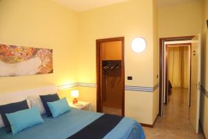 a bedroom with a bed with blue pillows at Bari Suite Apartment Leader Palace in Bari