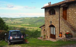 グレーヴェ・イン・キアンティにあるAgriturismo Poggio all'Olmoの石造りの家の前に停められた車