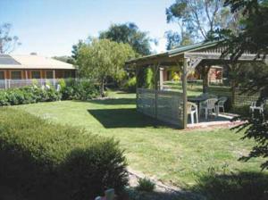 een achtertuin met een prieel en een tafel en stoelen bij Aristocrat Waurnvale in Geelong