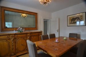 a dining room with a wooden table and a mirror at Schwarwald Apartment in Schluchsee
