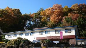 een wit gebouw met bomen op de achtergrond bij Hotel Togariishi in Chino