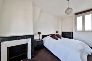 ルヴァロワ・ペレにあるBelle vueの白いベッドルーム(暖炉、ベッド付)