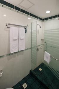 a bathroom with a shower and a toilet and towels at Sunway Hotel Hanoi in Hanoi