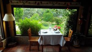 einem Tisch mit einem weißen Tischtuch vor einem Fenster in der Unterkunft Hotel Rural El Camino in Candeleda