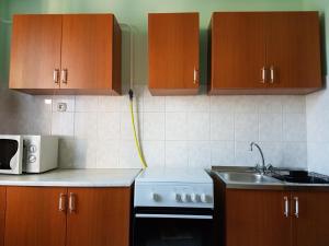 a kitchen with wooden cabinets and a sink at Tó úti Vendégház in Mezőtúr