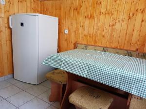 a kitchen with a table and a refrigerator at Tó úti Vendégház in Mezőtúr
