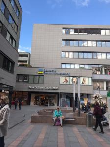 a woman sitting on a bench in front of a building at Am Brand in Mainz