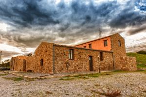 an old brick building with a tower on top of it at Agriturismo Case Tabarani in Collesano