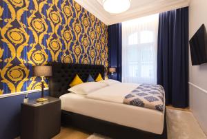 1 dormitorio con 1 cama y pared azul y amarilla en Abieshomes Serviced Apartments - Votivpark, en Viena