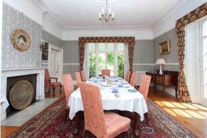 a dining room with a table and a fireplace at Hollybank House in Emsworth