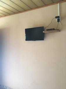 a flat screen tv on a wall with a shelf at Cantinho da Paz in São Pedro da Serra