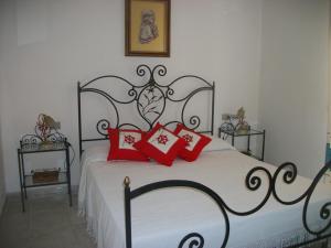 サン・テオドーロにあるCasa Tavolaraのベッドルーム1室(赤黒のベッド1台、赤の枕付)