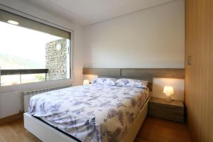 a bedroom with a bed and a large window at Higer Bidea 1 - Basquenjoy in Hondarribia