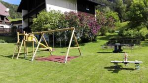 einen Park mit einer Schaukel im Gras in der Unterkunft Pension & Ferienwohnung Sonnleiten in Gnesau