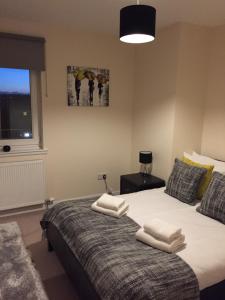 a bedroom with a bed with white towels on it at AB11 Apartments - Portland Street in Aberdeen