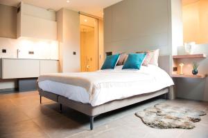 a bedroom with a large bed with blue pillows at Atelier 24 in Sint-Pieters-Leeuw