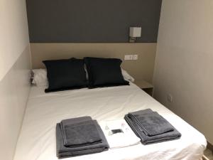 マドリードにあるホスタリン マドリード アトーチャのベッド(黒い枕、タオル付)