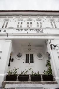 a white building with a sign that reads the southern hotel at The Southern Boutique Hotel in George Town