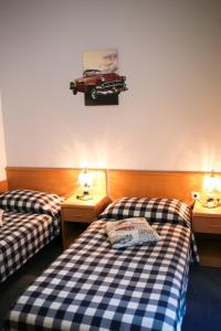 two beds in a room with a car on the wall at Hotel Veli Jože in Pula