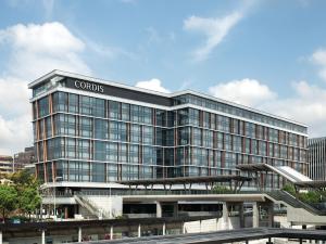 a large glass building with a sign on it at Cordis Shanghai Hongqiao (Langham Hospitality Group) in Shanghai