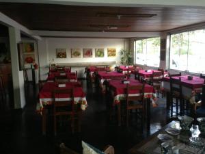 a dining room with pink tables and chairs in a restaurant at Pousada de Ubu in Anchieta