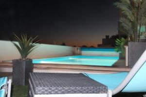 a swimming pool at night with a bench in the foreground at Olive View in Vila Nova da Barquinha