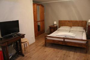 um quarto com uma cama e uma televisão de ecrã plano em Zimmer David em Colônia
