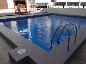 a swimming pool with two metal rails in a building at Acogedora Vivienda Vacacional en Candelaria in Candelaria