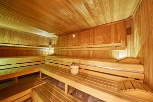 a sauna with wooden benches and a bucket in it at Appartement Ski & Bike in Saalbach Hinterglemm