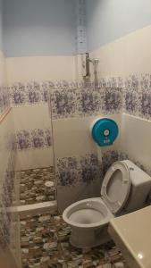 a bathroom with a toilet with blue and white wallpaper at Three Bays Resort in Prachuap Khiri Khan