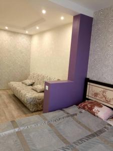 ヤロスラヴリにあるApartment on Bogdanovicha 8の紫の壁のベッドルーム1室(ベッド1台付)