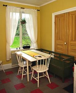een kamer met een tafel en stoelen en een raam bij Smultronboda Fårgård in Edsbruk