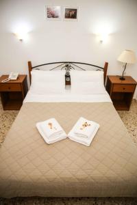 a hotel room with two beds and a lamp at Anixis Hotel in Loutra Ipatis