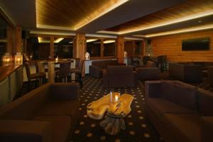 a restaurant with couches and a table with a guitar at Hotel Splendid in Sauze dʼOulx