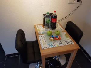 ein Tisch mit zwei Flaschen Limonade und Äpfeln darauf in der Unterkunft Appartement Stein EG in Fritzlar