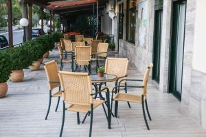 a group of chairs and tables on a sidewalk at Anixis Hotel in Loutra Ipatis