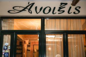 a store front with a window and a sign at Anixis Hotel in Loutra Ipatis