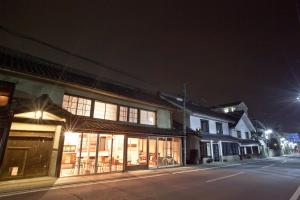 an empty street at night with buildings and lights at Guest House Kura in Suzaka
