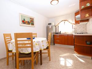 kuchnia ze stołem i krzesłami oraz kuchnia z lodówką w obiekcie Apartment Nevenka 1482 w Medulinie