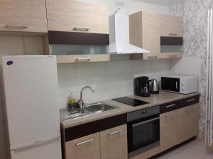 a kitchen with a sink and a white refrigerator at VBE apartments in Narva