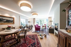 een woonkamer met een tafel en stoelen en een woonkamer bij Gästehaus Schusser an der Therme in Bad Kleinkirchheim