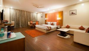 um quarto de hotel com uma cama e uma sala de estar em Airport Hotel Ramhan Palace Mahipalpur em Nova Deli mais 37 fotografias